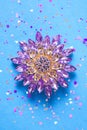 Round brooch flower in spangles isolated on blue background