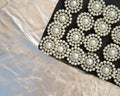Round brooch with pearls on a black and silver background