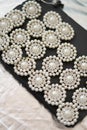 Round brooch with pearls on a black and silver background