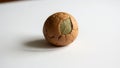 A round brown clay object with a cracked surface sits on a white backgroun Royalty Free Stock Photo