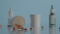 Round brown pills scattered from bottle on table on blue background. Brown tablets against the background of various Royalty Free Stock Photo