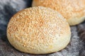 Round bun, sesame bun, bread rolls. Tasty burger bread with sesame on wooden, burlap background. Freshly baked hamburger buns. Top Royalty Free Stock Photo