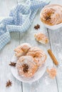 Round cakes with vanilla cream and powdered sugar on a wooden table, white vintage crockery, top view