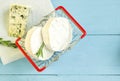 Round camembert and blue cheese mold with rosemary in a shopping cart