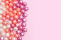 Round candies in glaze. Candy pearls. White, orange and purple. Pink Background. Flat lay. Top view. Copy space. Place