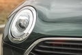 Round car headlight details grid radiator hood green color Royalty Free Stock Photo