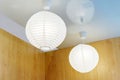 Round ceiling lampshades made of fabric on a wooden wall background. Home lighting close-up