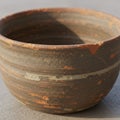 A round ceramic bowl with rough, textured surface, featuring a blend of earthy brown Royalty Free Stock Photo