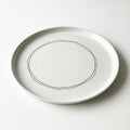Round ceramic plate with a minimalist design. Features a simple black outlined circu Royalty Free Stock Photo