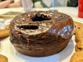 Round chocolate bundt cake with chocolate frosting surrounded bu chocolate chip cookies