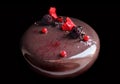 Round chocolate cake with berries on black background