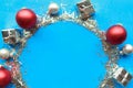 Round Christmas tinsel silver frame with red baubles and decorations. Royalty Free Stock Photo