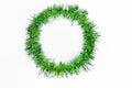 Round circle of bright green tinsel on a white background. Christmas decorations. New year