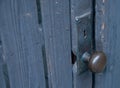 Round classic metal lock with key hold on wooden door Royalty Free Stock Photo