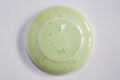 Round clay sample covered with soft green glossy glaze
