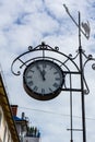 Round clock on the sky background. The street clock shows five minutes to twelve. Royalty Free Stock Photo