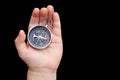 Round compass in hand on black background