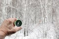 Round compass in hand on winter birch forest background Royalty Free Stock Photo