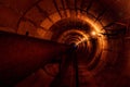 Round concrete underground tunnel of heating duct system with rusty pipes Royalty Free Stock Photo