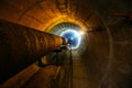 Round concrete underground tunnel of heating duct system with rusty pipes Royalty Free Stock Photo