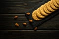 Round cookies on a black serving board and almonds prepared for dessert at the hotel. Sweet snack or dessert concept on vintage