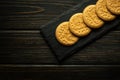 Round cookies on a black serving board prepared for dessert at the hotel. Sweet snack or dessert concept on vintage dark table