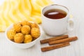 Round cookies in bowl, napkin, cup of tea, cinnamon stick Royalty Free Stock Photo
