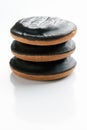 Round cookies covered in chocolate lie on top of each other on a white vertical background with copy space at the bottom. The Royalty Free Stock Photo