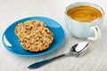 Cookies with different seeds in saucer, spoon, black coffee in cup on wooden table Royalty Free Stock Photo