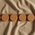 Round cork coasters arranged in a row on a beige fabric surface. Each coaster has a Royalty Free Stock Photo