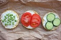 Round crispy corn sandwiches with vegetables toppings. Puffed corn cakes with cream cheese, tomatoes, cucumbers, and peas