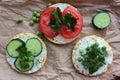 Round crispy corn sandwiches with vegetables toppings. Puffed corn cakes with cream cheese, tomatoes, cucumbers, and peas on craft