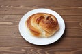 round danish bread on plate  on wooden table Royalty Free Stock Photo