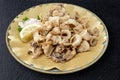 Round dish with fried squid with sauce and lemon wedge Royalty Free Stock Photo