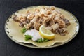 Round dish with fried squid with sauce and lemon wedge Royalty Free Stock Photo