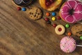 Round donuts, cookies, and fruitcake, flat lay dessert on wooden table with candy