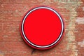 Round empty red banner hanging on a brick wall Royalty Free Stock Photo