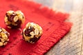 Round energy balls handmade from is lying on red napkin on wooden table.