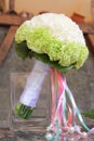 Round, even bridal bouquet of two shades of carnation on the background of the house