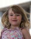 Round-faced adorable little girl with very wind-blown dirty blonde hair Royalty Free Stock Photo