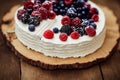 Round festive fruit cake with white cream and decoration of fresh berries