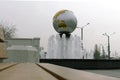 Round fountain in the city, decorated with a small copy of the globe.