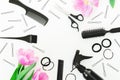 Round frame with hairdresser tools - spray, scissors, combs, barrette and tulips on white background. Flat lay, top view Royalty Free Stock Photo