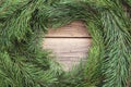 Round frame made of Christmas pine tree branches on old wooden Royalty Free Stock Photo