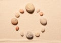 Round frame of sea stones on sand. Summer beach background Royalty Free Stock Photo