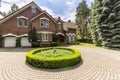 Round garden on driveway of english house in the forest during s