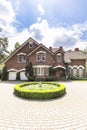 Round garden and paving in front of a big, english style house Royalty Free Stock Photo