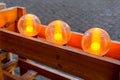 Round glass lantern with an orange lamp on the wooden fence. Royalty Free Stock Photo