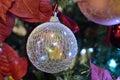 Round glass ornament with decorative mesh reflecting colorful lights