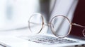 Round glasses resting on a laptop keyboard. The scene conveys a modern workspace atmosphere, emphasizing technology and vision. Royalty Free Stock Photo